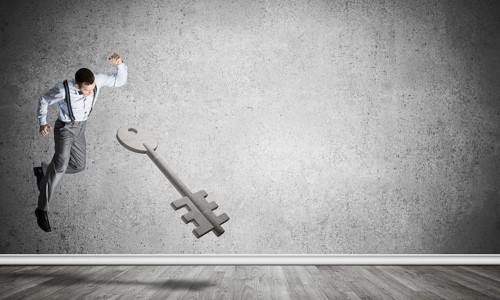 Determined businessman in empty interior breaking with fist stone key figure