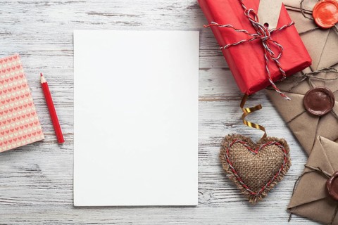 Flat lay composition with handmade fabric heart and gift box. Blank sheet of white paper on wooden