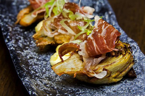 Roasted artichoke hearts with slices of raw ham, jamon de bellota