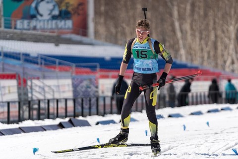 Sportsman biathlete Khanzutin Artem skiing on ski track distance biathlon stadium during Junior