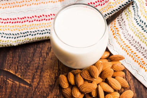 Almond milk with almond on a wooden table