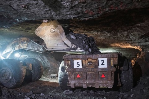 The loader pours copper ore on a truck in the mine