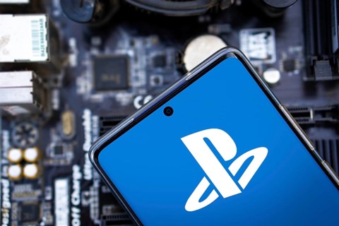 Person holding cellphone with logo of video gaming platform PlayStation Network (PSN) in front of
