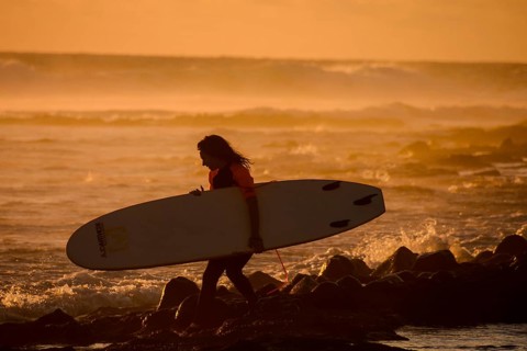 Single surfer at sunset on a calm ocean