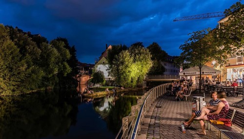 Germany, 07 26 2018: Tourists and locals sitting at the banks of the Pegnitz river, Europe