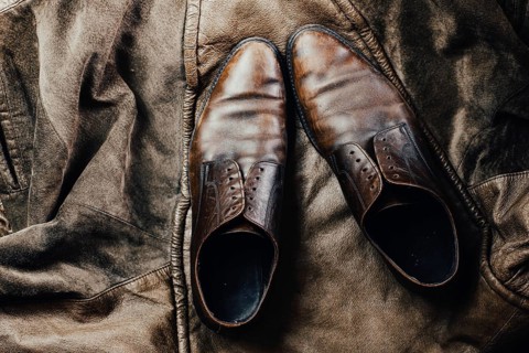 Brown leather shoes paired with a leather jacket, enhancing a vintage and rustic feel