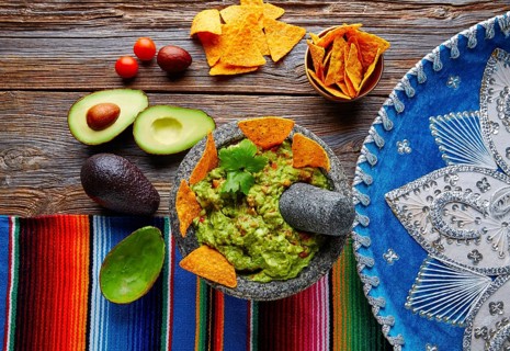 Guacamole with nachos avocado in Mexican molcajete and Sombrero hat