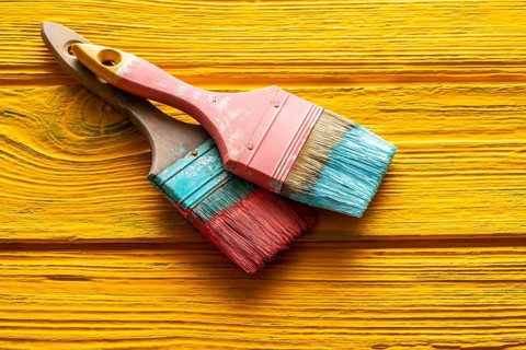 Coral color and yellow vivid grunge brushes on aged painted wood