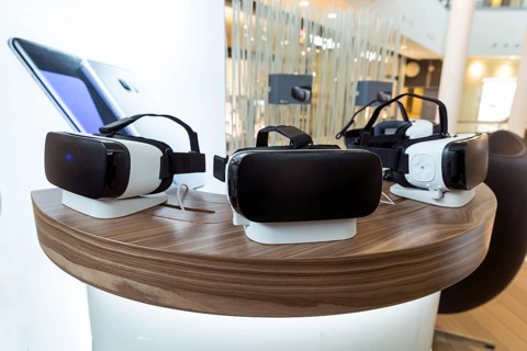 Virtual reality (VR) headsets (glasses) on a table. VR is immersive multimedia or