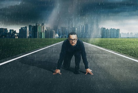 Young businessman starting position to his career with city skyline background, raining day .
