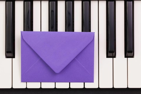 Funny arrangement envelope on the piano keybords - Flat lay image