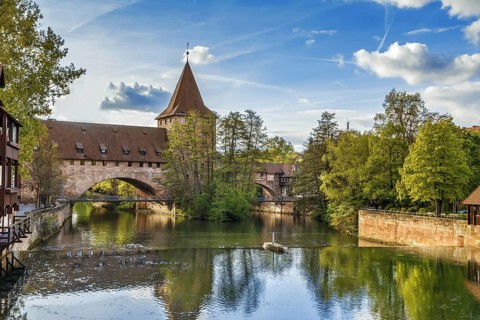 Pedestrian chain bridge (Kettensteg) and the medieval city wall behind it, Nuremberg, Germany,