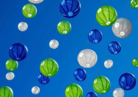 Party with colourful lampions hanging under a blue sky