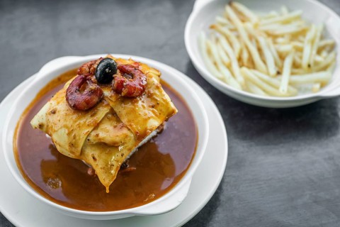 Famous francesinha traditional meat cheese and spicy sauce grilled sandwich of porto portugal