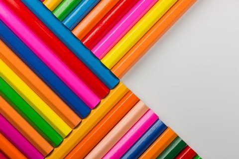 Abstract composition of a set wooden colour pencils against a white background