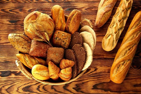 Bread fresh varied mix on golden rustic wood in basket