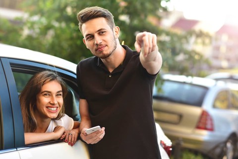 Beautiful girl sitting in the car and flirting with guy who outdoor standing