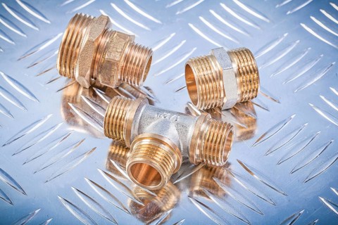 Brass hose nipples equal tee on fluted metal sheet plumbing concept