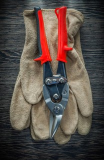 Protective gloves steel cutter on wooden board