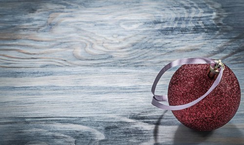 Red Christmas round toy on wooden board holidays concept