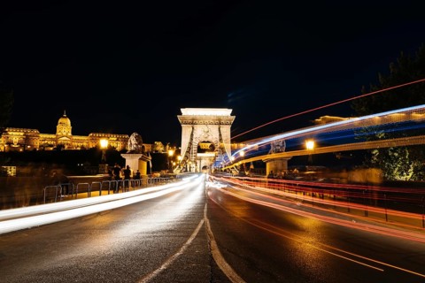 Chain Bridge and Buda castle illuminated in Budapest at night. Long exposure shot with light trails
