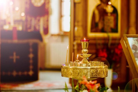A church interior with a brass candle holder featuring lit candles