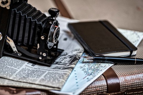 Still life with an old camera, pen, glasses and a road map in vintage style. Memories from