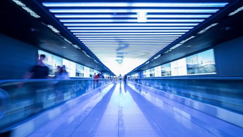 People going in walkway and riding flat escalators at the airport of Seoul, South Korea. Futuristic