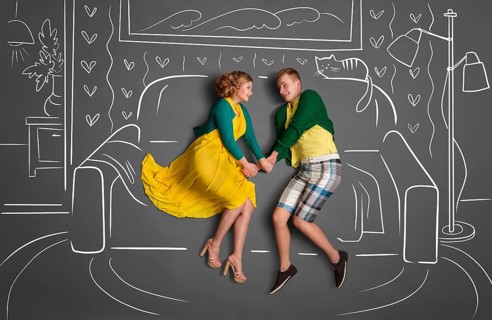 Happy valentines love story concept of a romantic couple sitting on a sofa and holding hands
