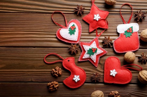 Handmade rustic Christmas tree decorations with walnuts and cones on wooden table