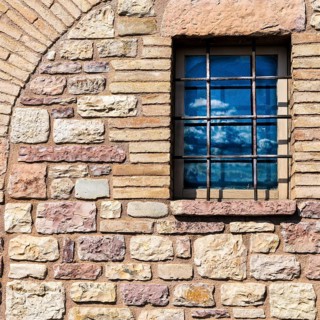 Assisi Italy : Window on medieval stone wall