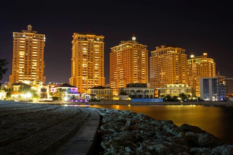 The skyline panorama of The Pearl-Qatar area buildings in Doha, Qatar at night. The Pearl-Qatar is