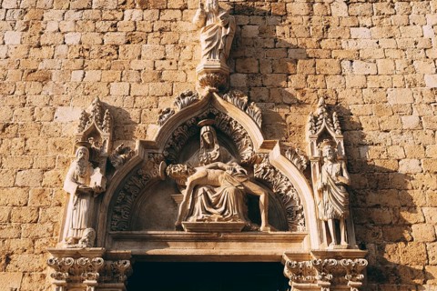 Facade of the Franciscan monastery with high relief depicting holy images in the old town of