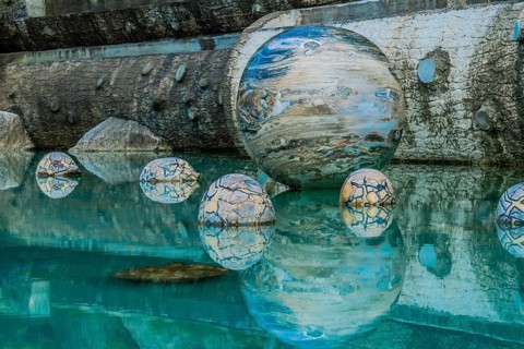 Sejong, South Korea, August 8, 2019: Marble sphere surrounded by smaller spheres in pool of water