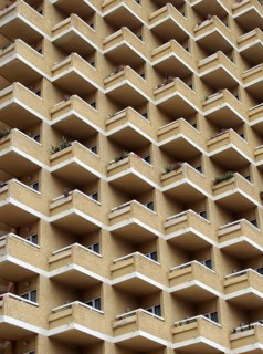 Large highrise modern apartment building with large number of repeating geometric balconies in