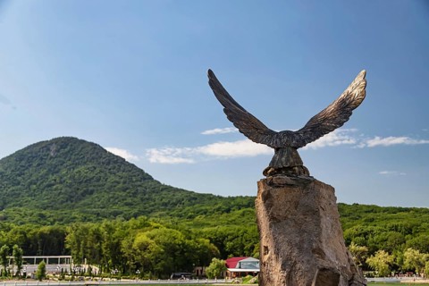 Bronze statue of the eagle-the symbol of the Caucasus on the background of mountains