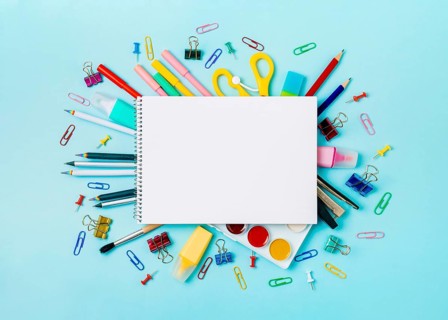 Notebook with stationary objects on blue background. Empty white paper sheet of notepad or