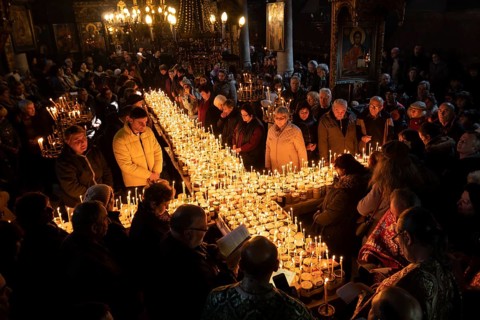Blagoevgrad, Bulgaria - February 10, 2019: Worshippers light candles on jars with honey during a