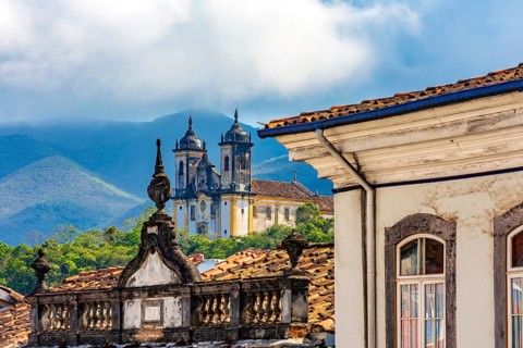 Facades of historic houses and churches with the mountains of the city of Ouro Preto in Minas