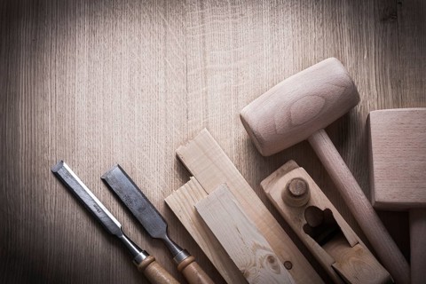 Wooden planks hammers planner flat chisels on wood background construction concept