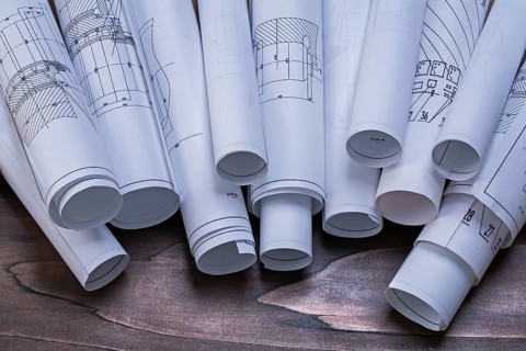 Rolls of construction plans on pine wooden vintage board maintenance concept