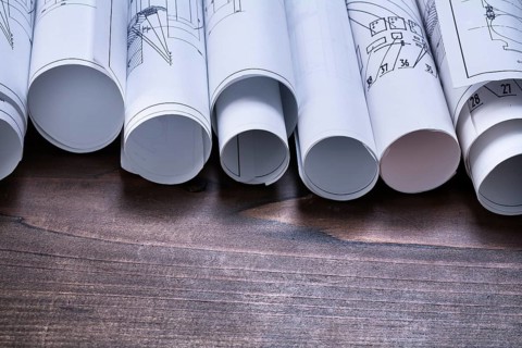 Pine wooden vintage board with stack of blueprint rolls construction concept