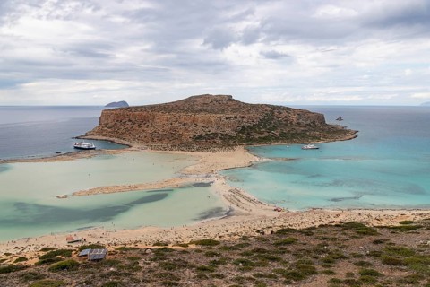A picture of the blue water of Balos Beach and the nearby landscape of the Gramvousa Peninsula