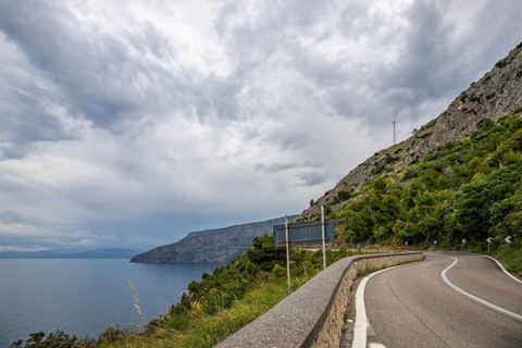 Coastal landscape shot. View from a road leading along the sea and through a breathtaking green