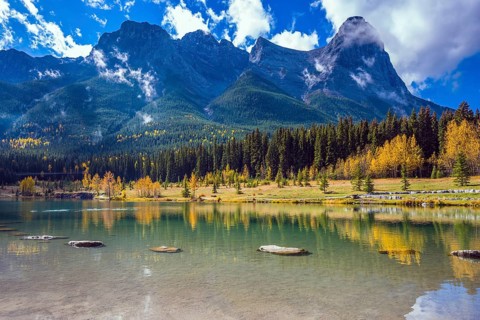 Shining day in Canmore. The famous Three Sisters mountains in the Canadian Rockies. Concept of