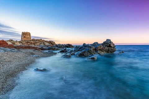 Old historic tower from the 16th century and rocks at sunset on the beach, long exposure, Torre di