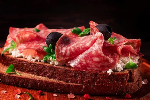 Sandwich, grain bread, with cream cheese and salami, black olives, micro-greens, top view,