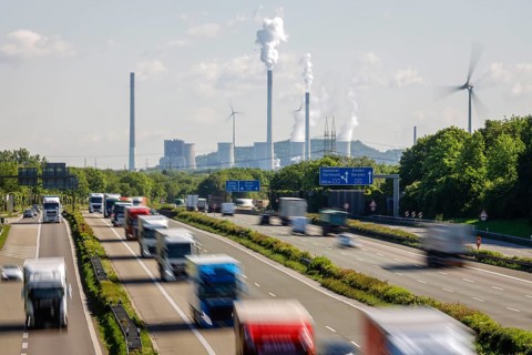 Many lorries driving on the A2 motorway, in the background the Uniper coal-fired power plant