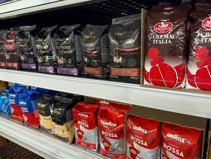 Display shelf with various types of packs of unground coffee beans, Germany, Europe