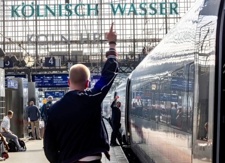 Central station with platform hall and travellers. Departure signal of the train chief for an ICE.